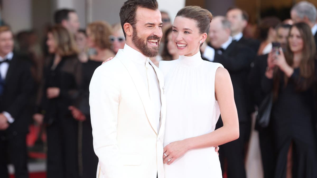 Justin Theroux and Nicole Brydon Bloom posing on red carpet at Venice International Film Festival