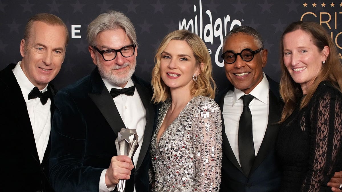 Bob Odenkirk, Peter Gould, Rhea Seehorn, Giancarlo Esposito, and Melissa Bernstein posing in a press room.