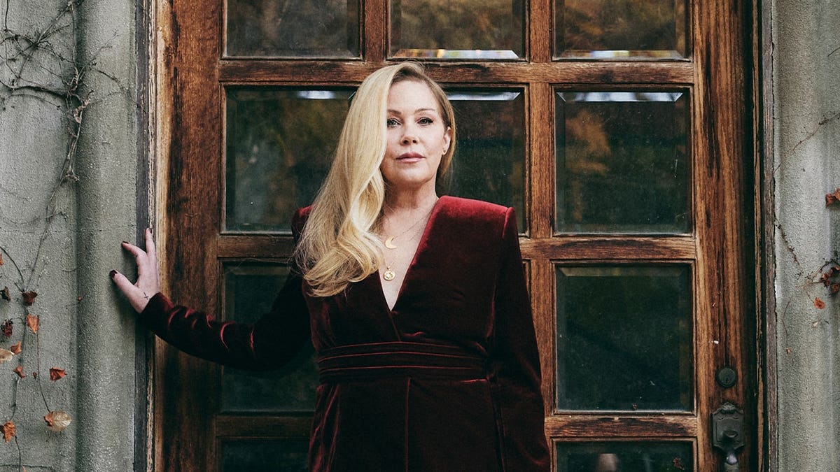 Christina Applegate poses wearing a red velvet dress