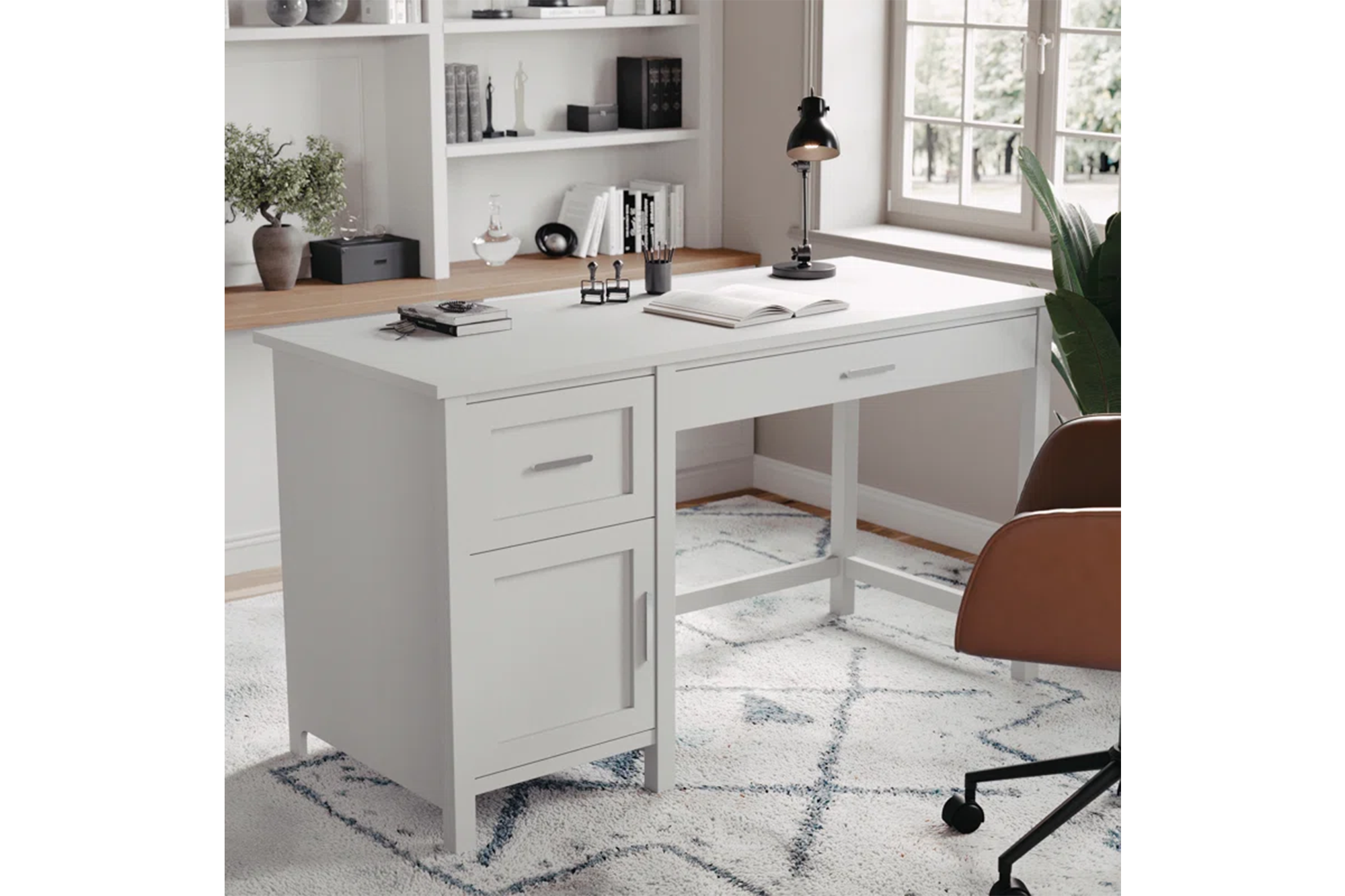 White wooden desk with a drawer, cabinet, and a black desk lamp.