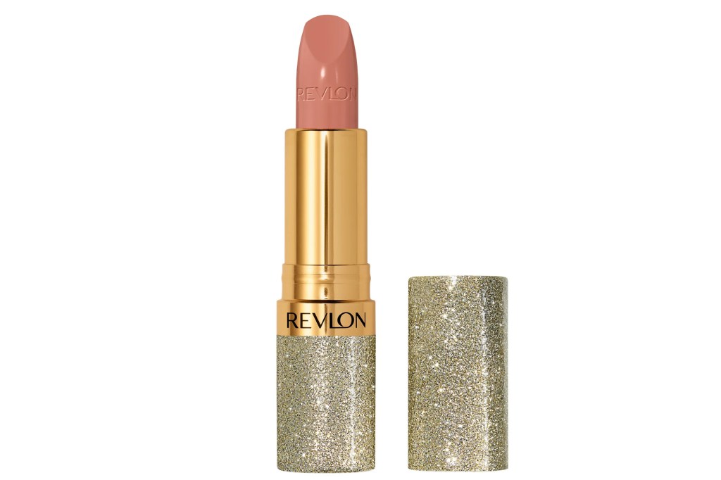 A Revlon lipstick in a gold glitter case with a nude-pink bullet, with the cap off to the right.