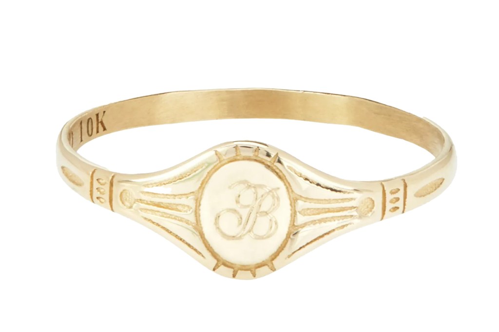 Gold ring with an oval-shaped signet featuring a cursive letter "B" and "10K" engraved on the band.