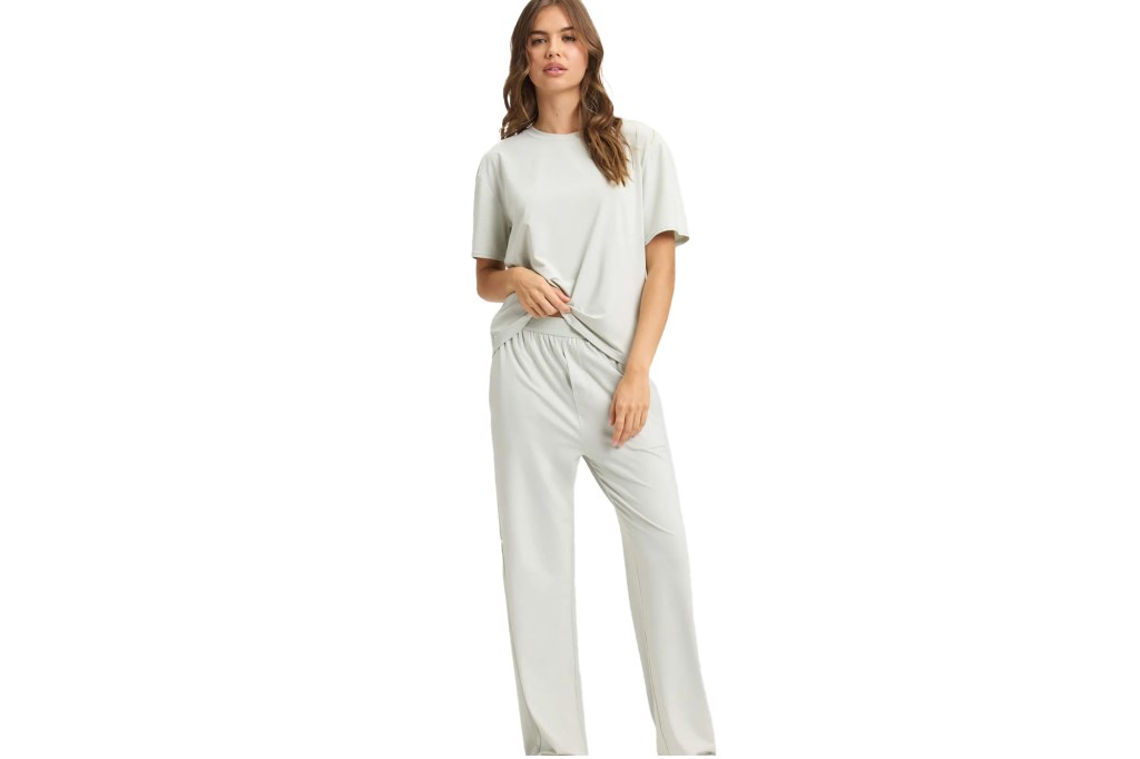 A woman wearing a light gray short-sleeved top and matching long pants.