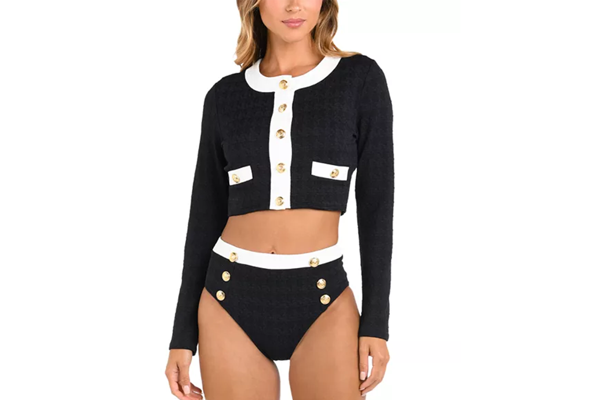 Model wearing a black and white cropped top and high-waisted bottoms with gold buttons.