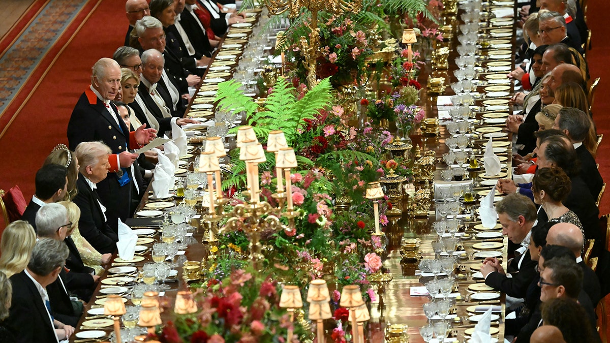 King Charles III standing beside President Donald Trump delivering a speech at Windsor Castle banquet