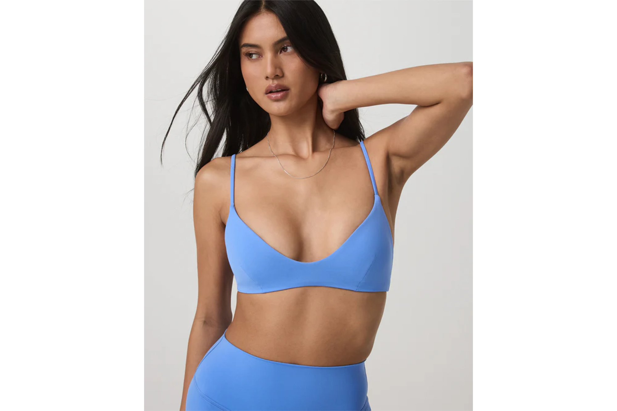 Woman wearing a light blue sports bra and matching leggings.