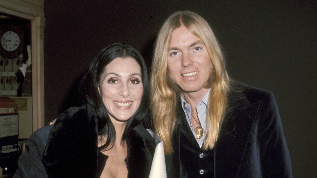 Singer Cher and musician Gregg Allman smiling and looking at the camera
