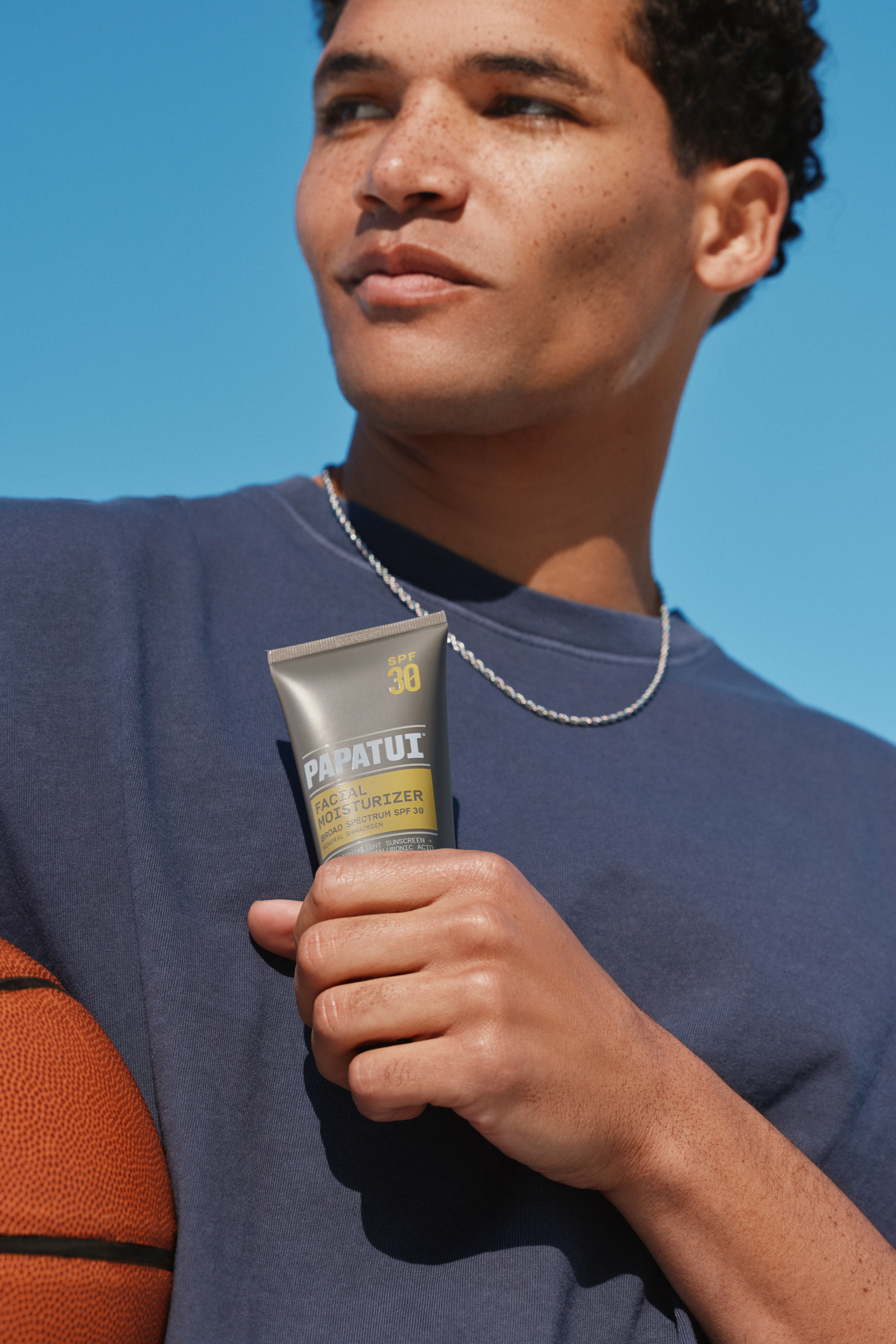 Man holding a tube of Papatui Facial Moisturizer with SPF 30.