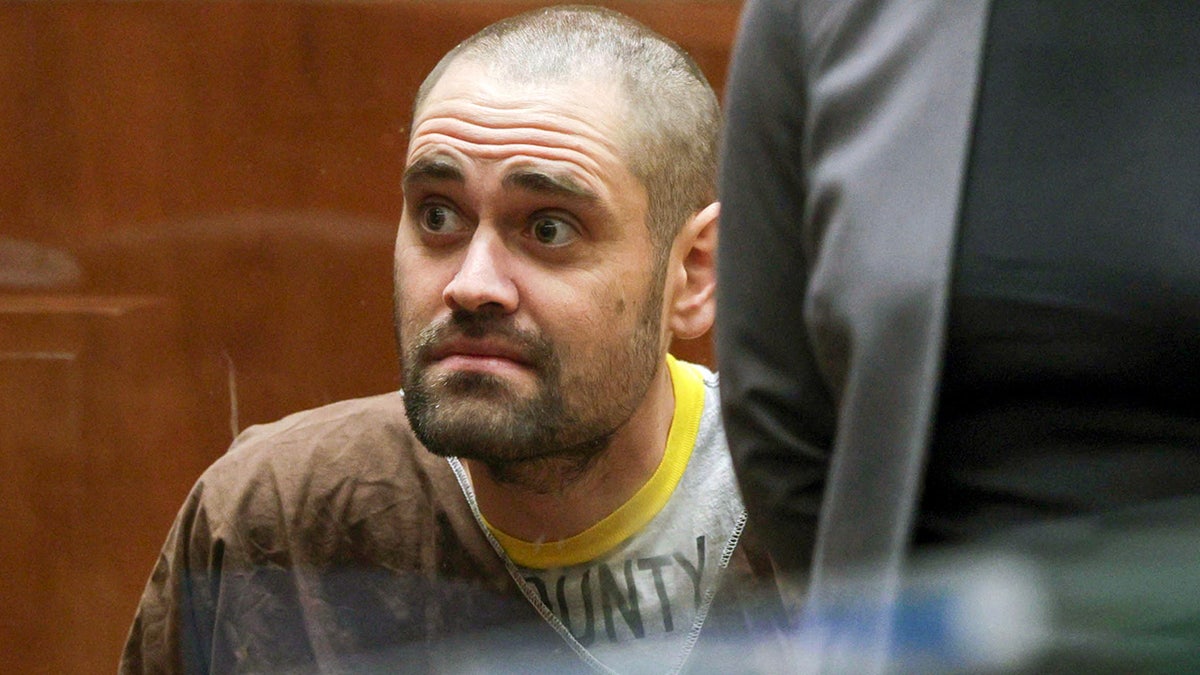 Nick Reiner wearing brown jumpsuit standing with Deputy Public Defender Kimberly Greene in courtroom