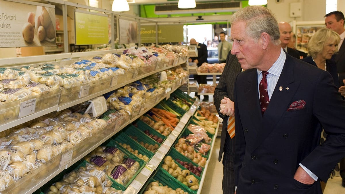 Prince Charles looking at vegetables displayed in Waitrose store.