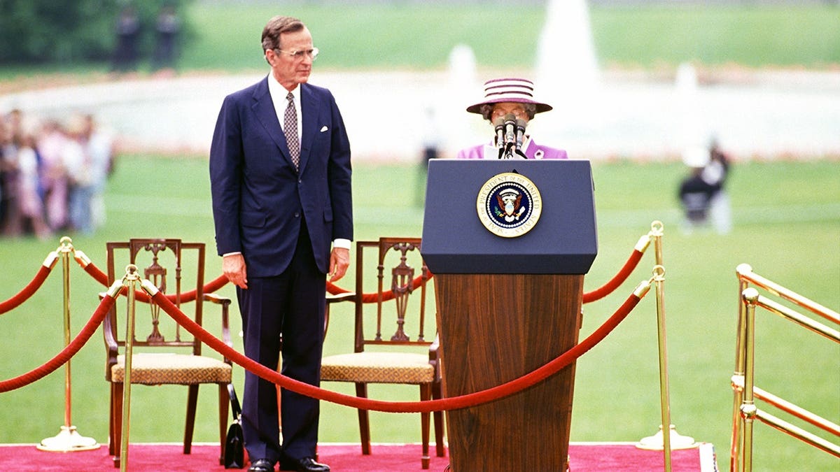 US President George HW Bush listening to Queen Elizabeth II speaking on the White House South Lawn