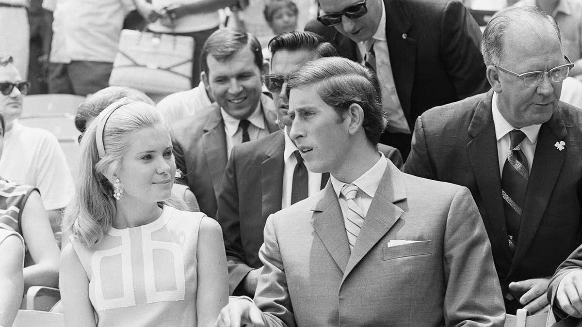 Prince Charles sitting with Tricia Nixon at a baseball game at RFK Stadium.