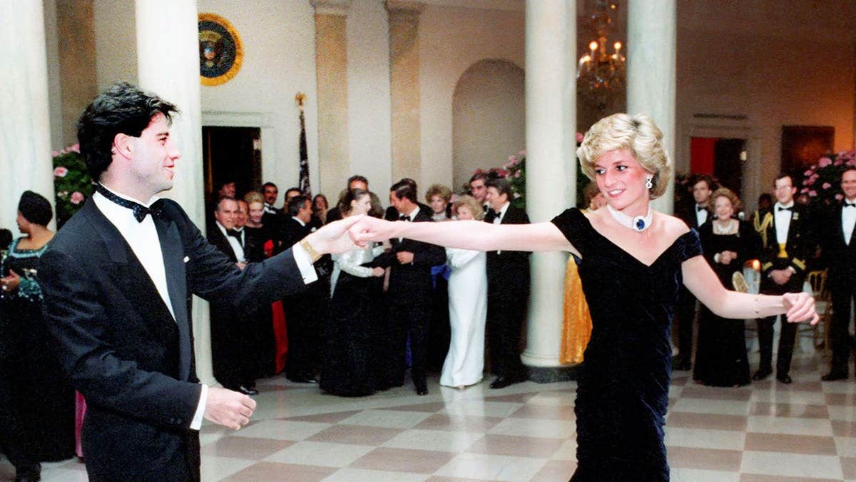 John Travolta in a suit dancing with Princess Diana wearing a dark blue velvet dress at the White House.