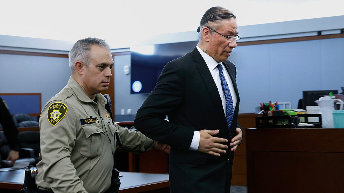 Nathan Chasing Horse escorted by court officials out of a courtroom in Las Vegas