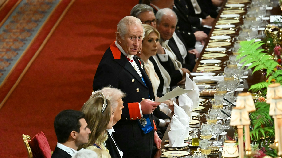 King Charles III standing and delivering a speech at a state banquet at Windsor Castle