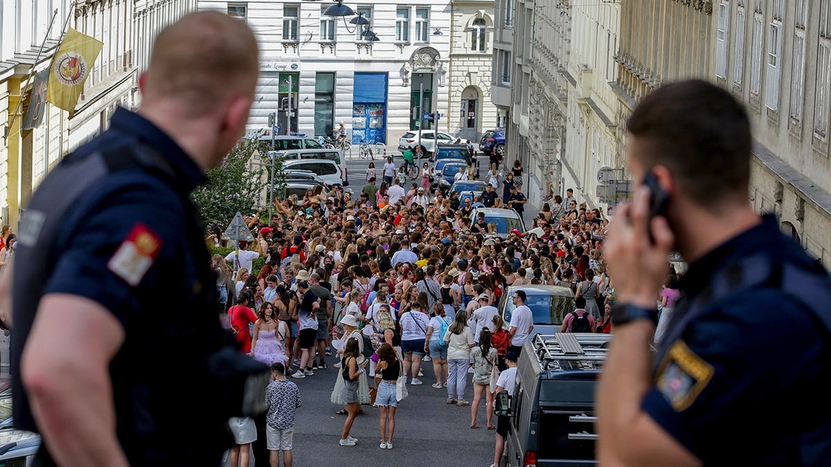 Austrian police officers watching a gathering of Taylor Swift fans in Vienna city centre