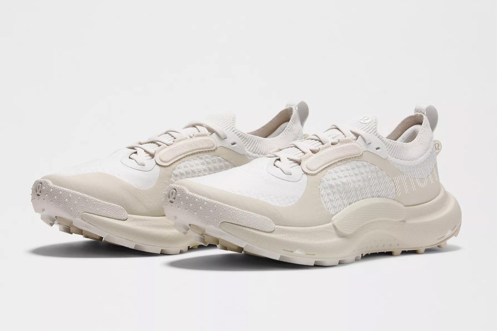 Pair of white and beige athletic sneakers with thick soles.