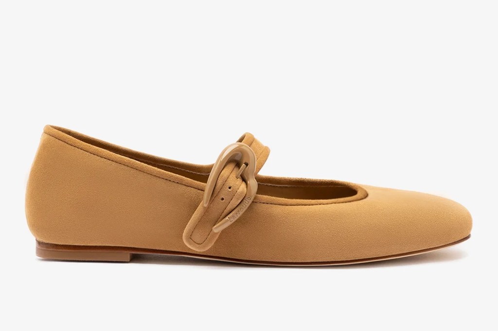 A light brown pea shoe with a brown heart-shaped buckle on the strap.