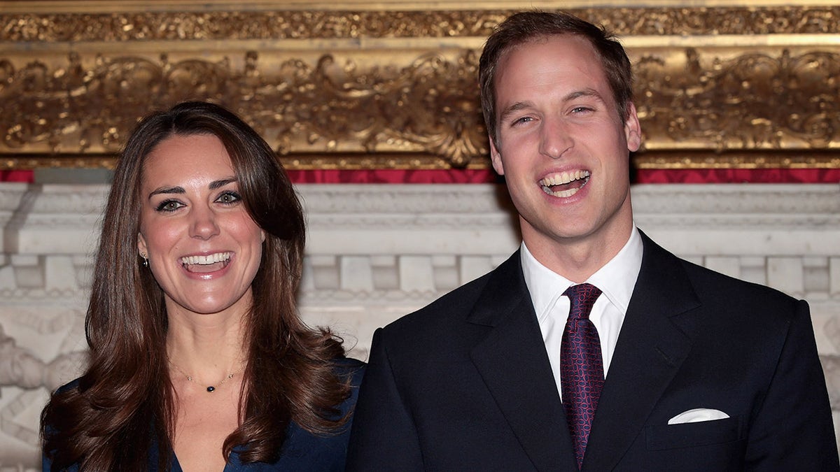 Prince William and Kate Middleton posing for photographs in St James Palace state apartments