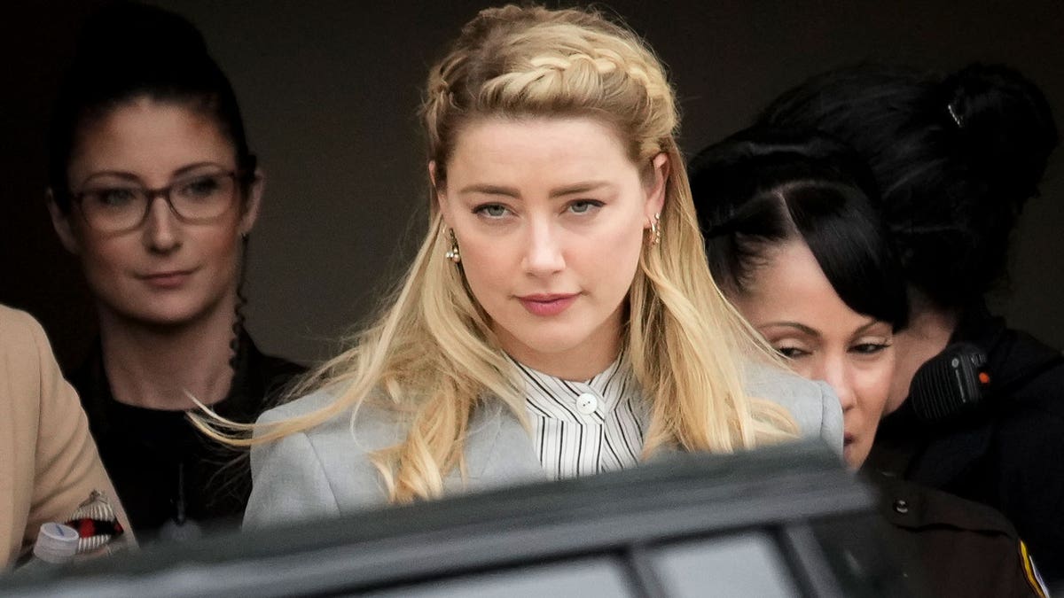 Amber Heard standing in court wearing a black outfit