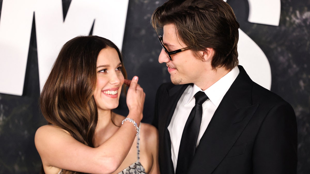 British actress Millie Bobby Brown and US actor Jake Bongiovi standing on a red carpet at the Paris Theater in New York