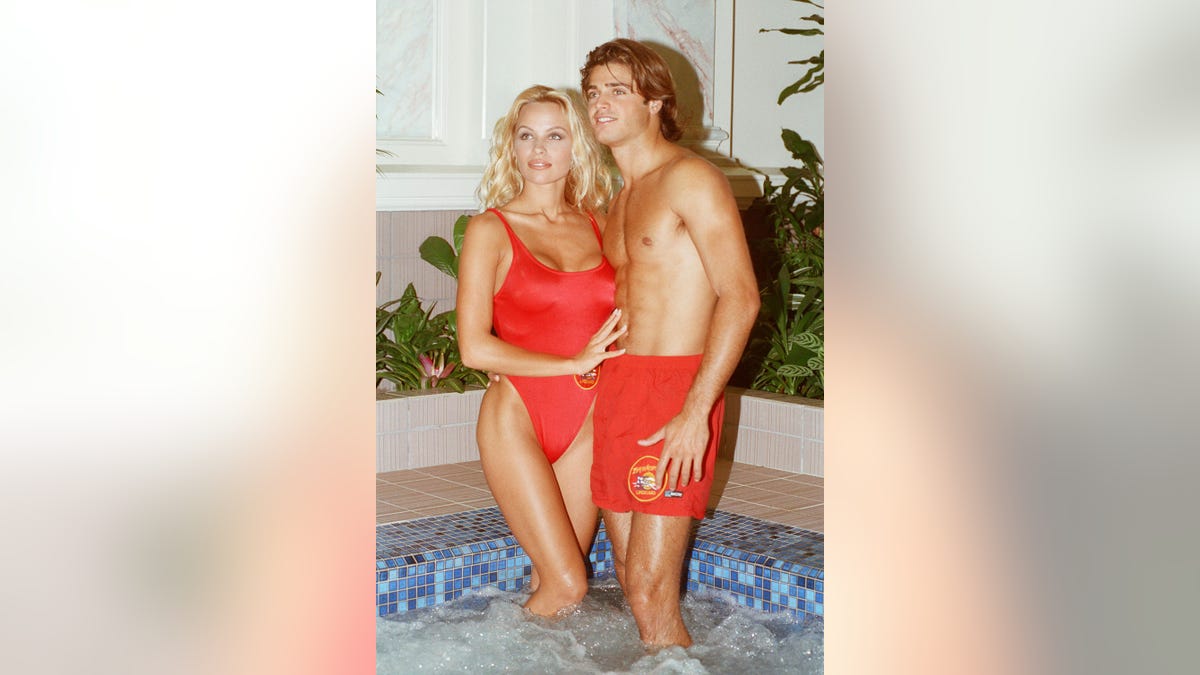 Pamela Anderson and David Charvet standing in swimsuits at a photocall in London