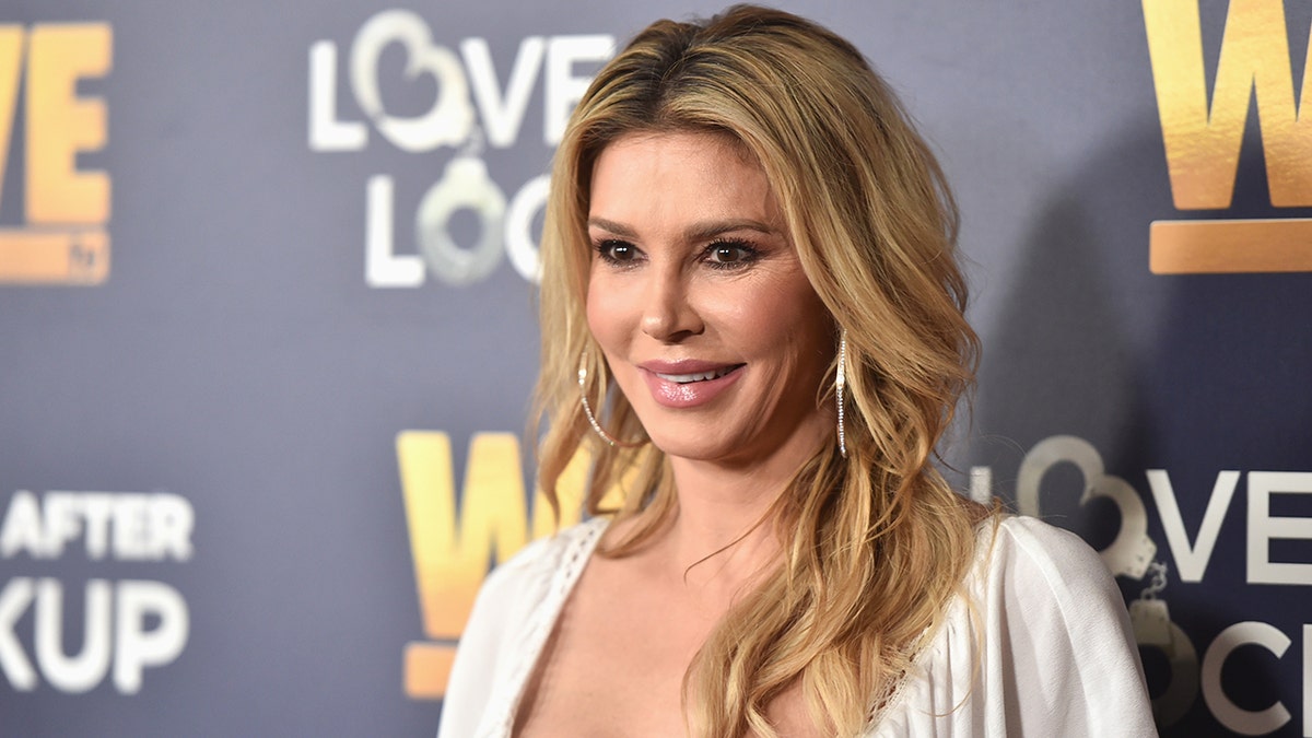 Brandi Glanville standing at a panel event in Beverly Hills, California.