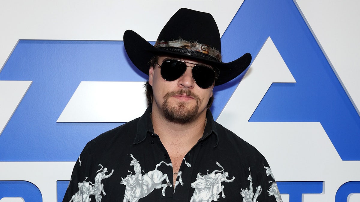 Gavin Adcock at the Madden Bowl event during Super Bowl LX in San Francisco, walking the blue carpet before a live performance.