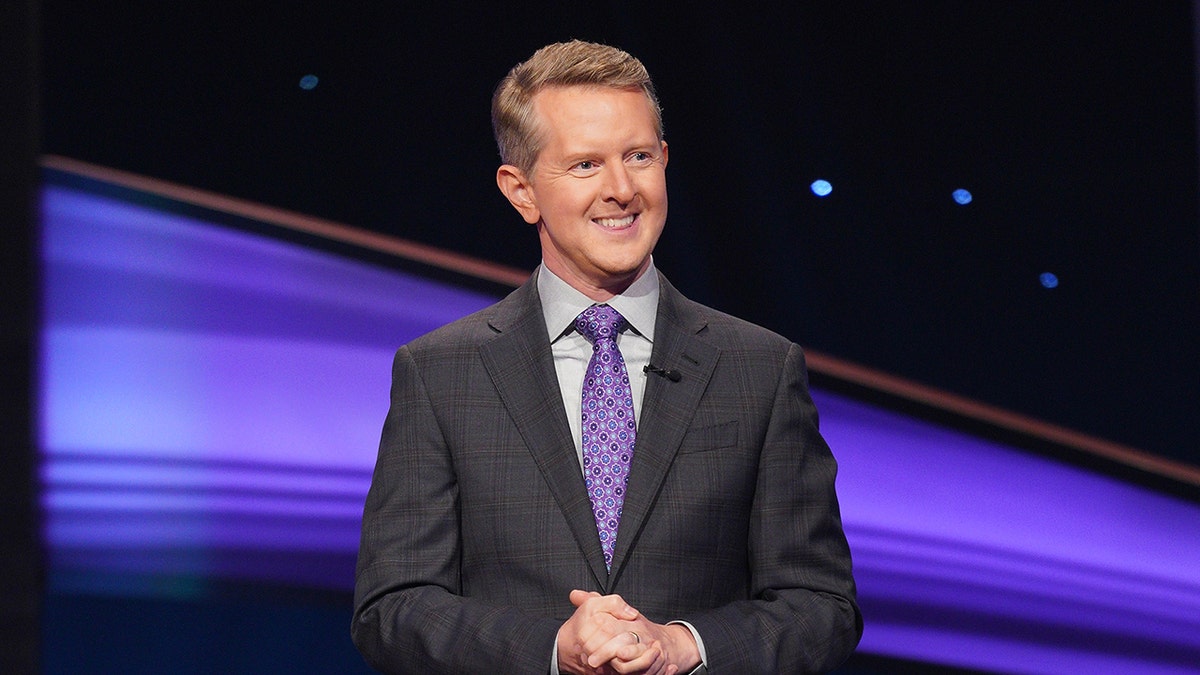 Ken Jennings smiling and standing on Jeopardy stage