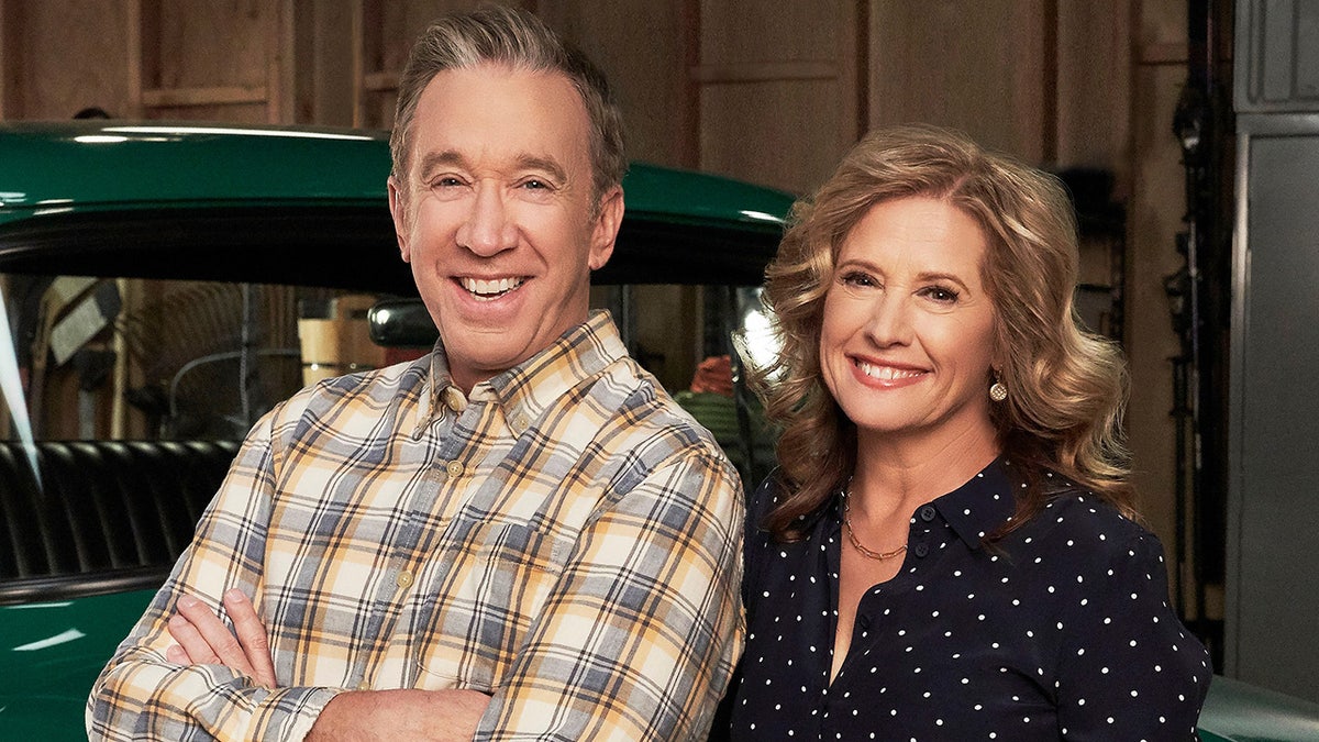 Tim Allen and Nancy Travis standing together on set