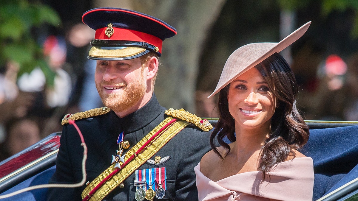 Prince Harry and Meghan Markle riding in a royal carriage during Trooping The Colour in London