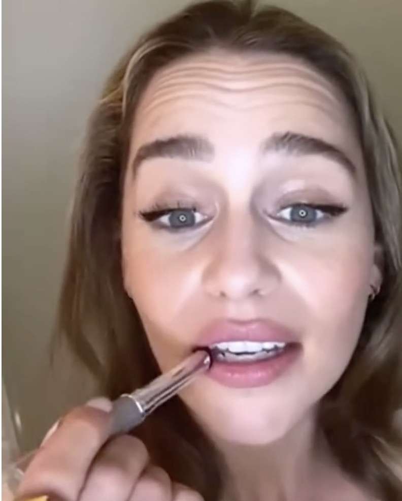 Woman applying lipstick.