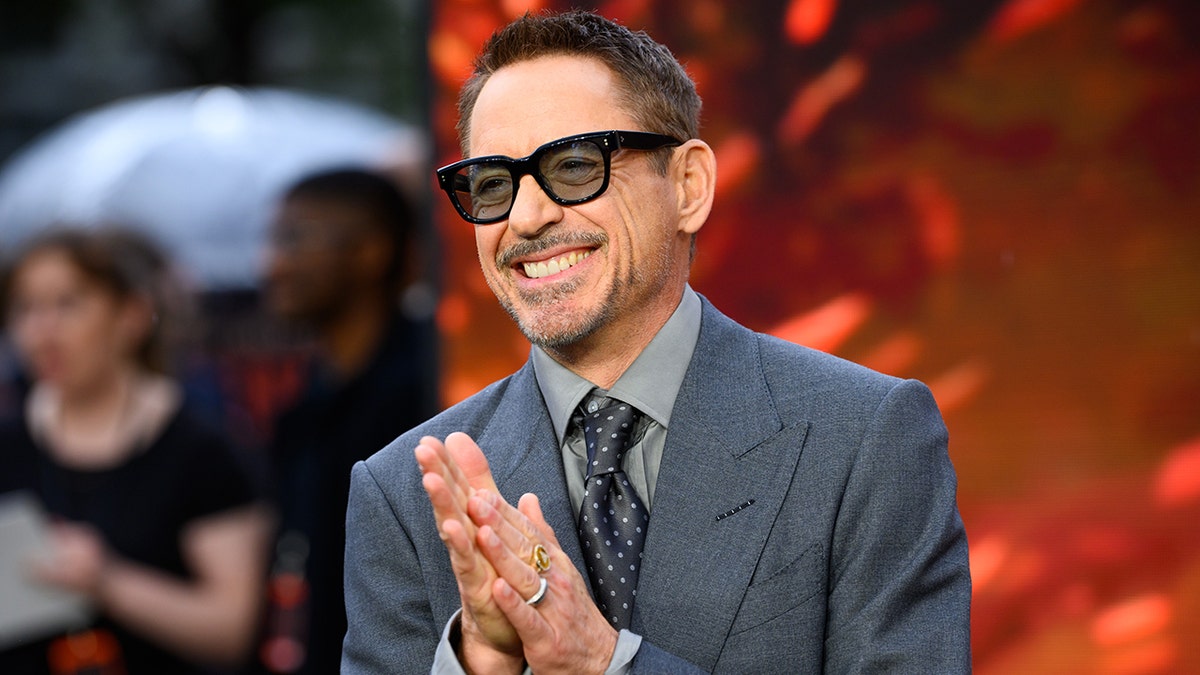 Robert Downey Jr. standing at the Oppenheimer premiere.