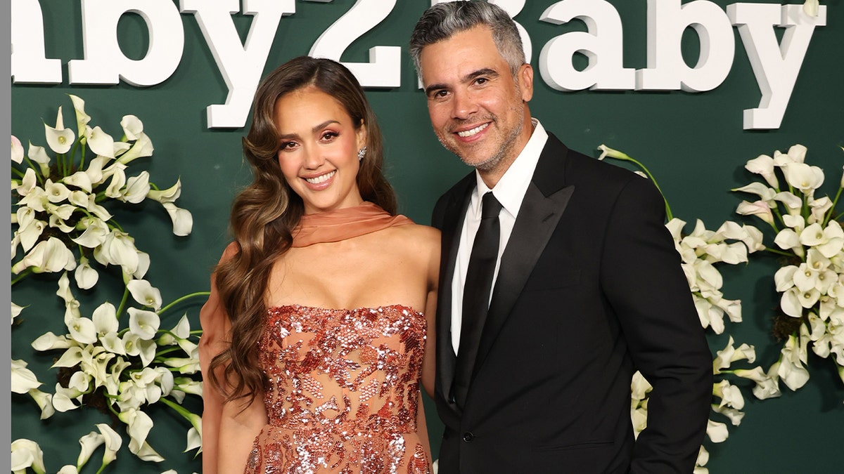 Jessica Alba and Cash Warren smiling at an event in West Hollywood, California.