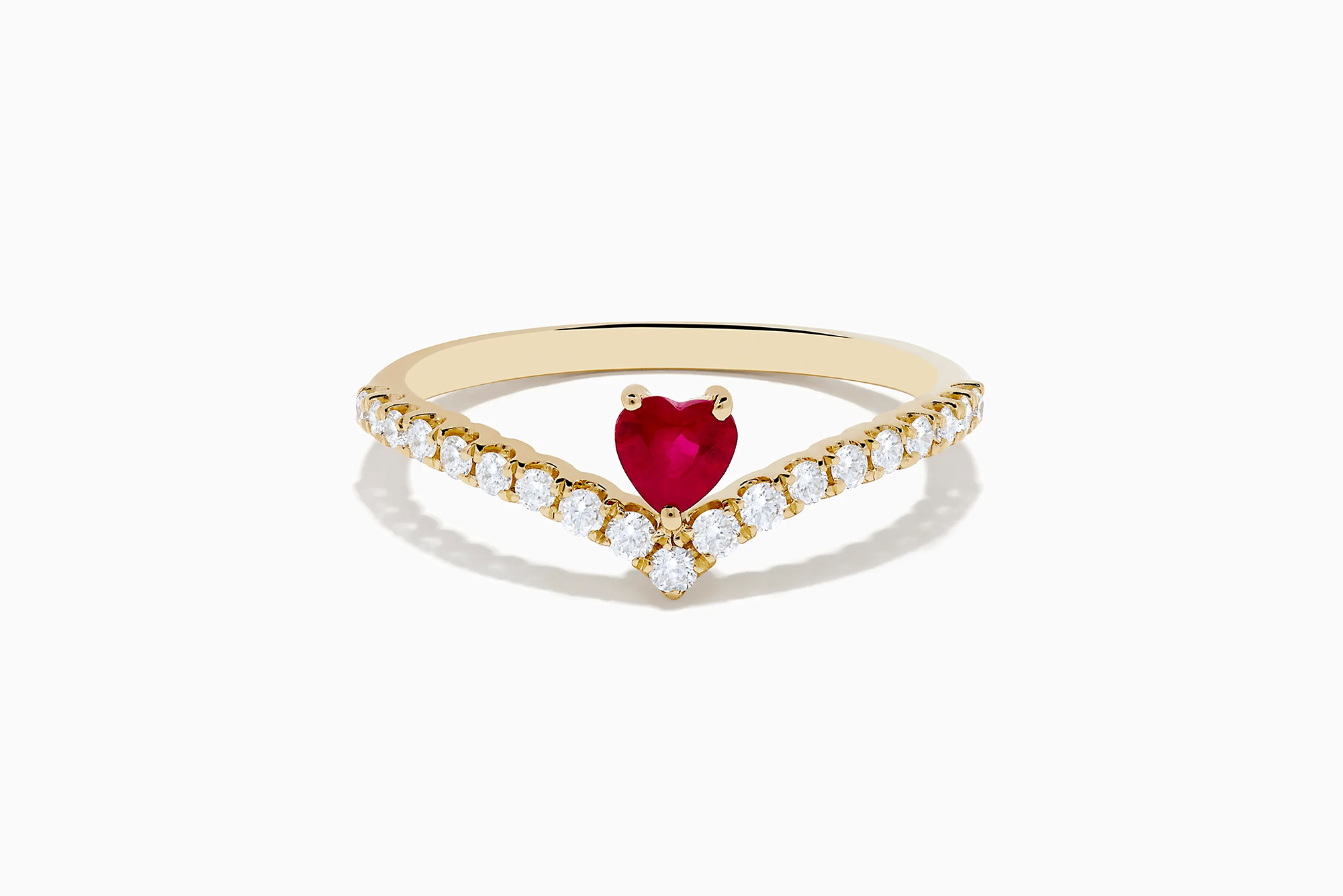 Gold ring with a heart-shaped red gemstone and white gemstones in a chevron pattern.