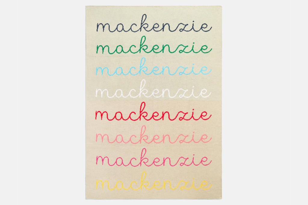 A rug with "mackenzie" embroidered in eight different colors.