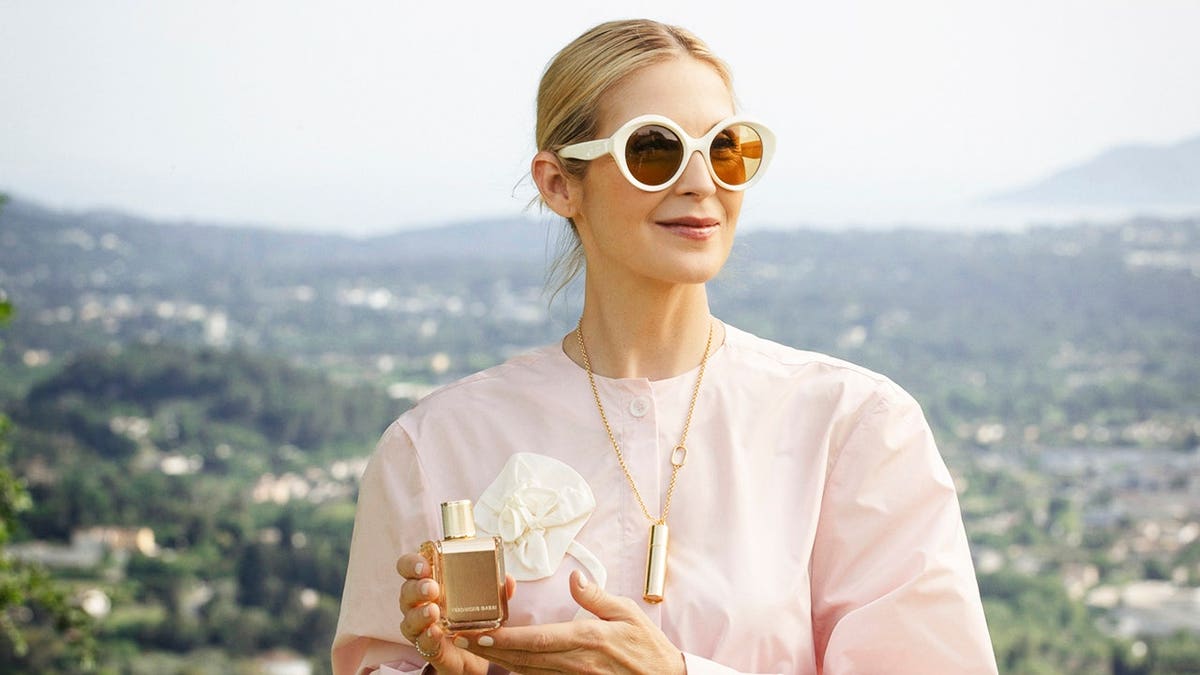 Kelly Rutherford holding her perfume bottle.