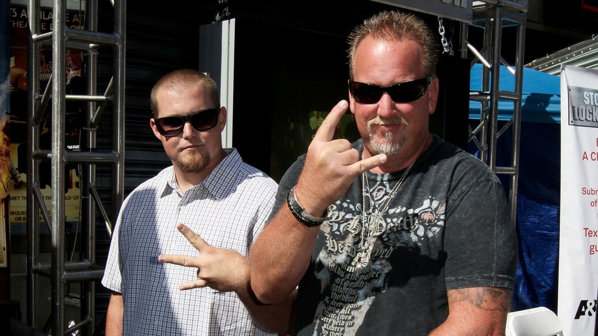 Darrell Sheets and his son throw up the peace sign