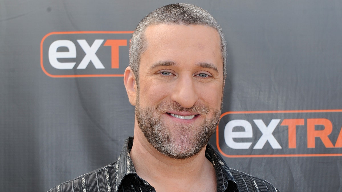Dustin Diamond smiling and seated during an interview on Extra