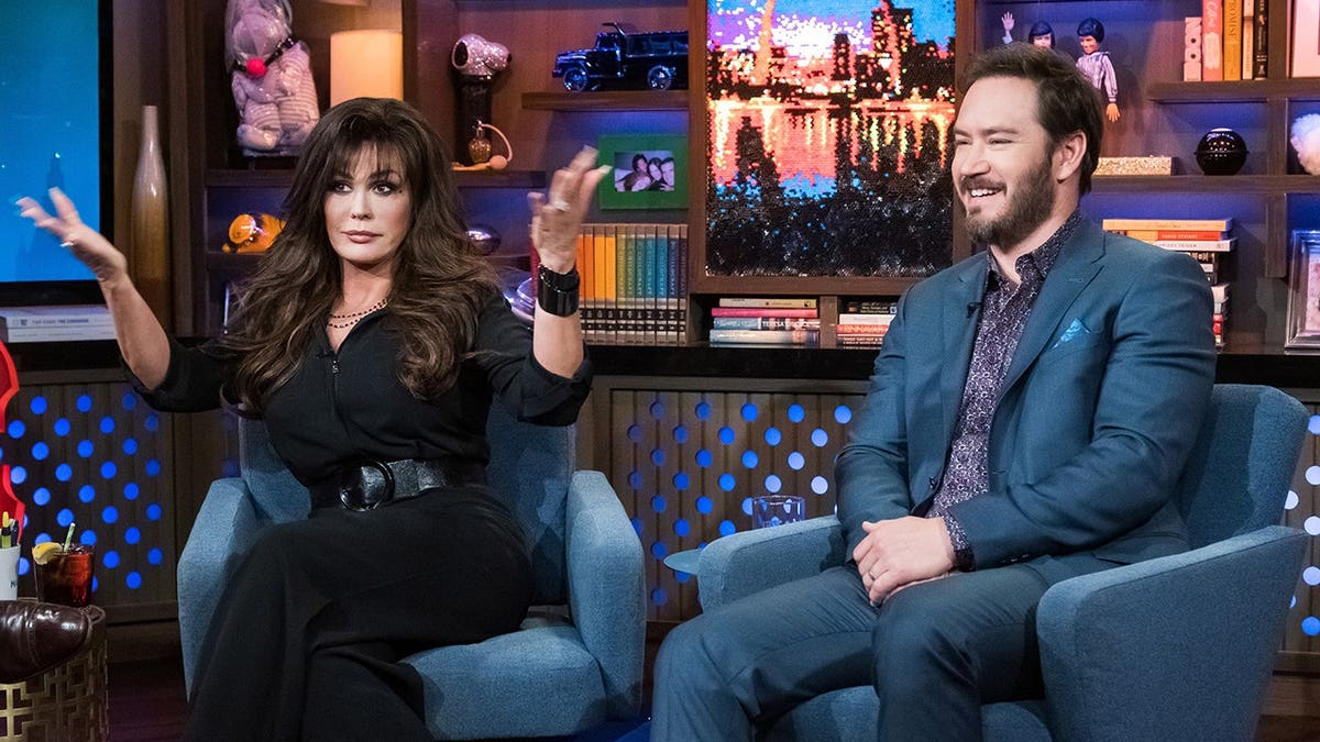 Marie Osmond and Mark-Paul Gosselaar seated together on a television set.