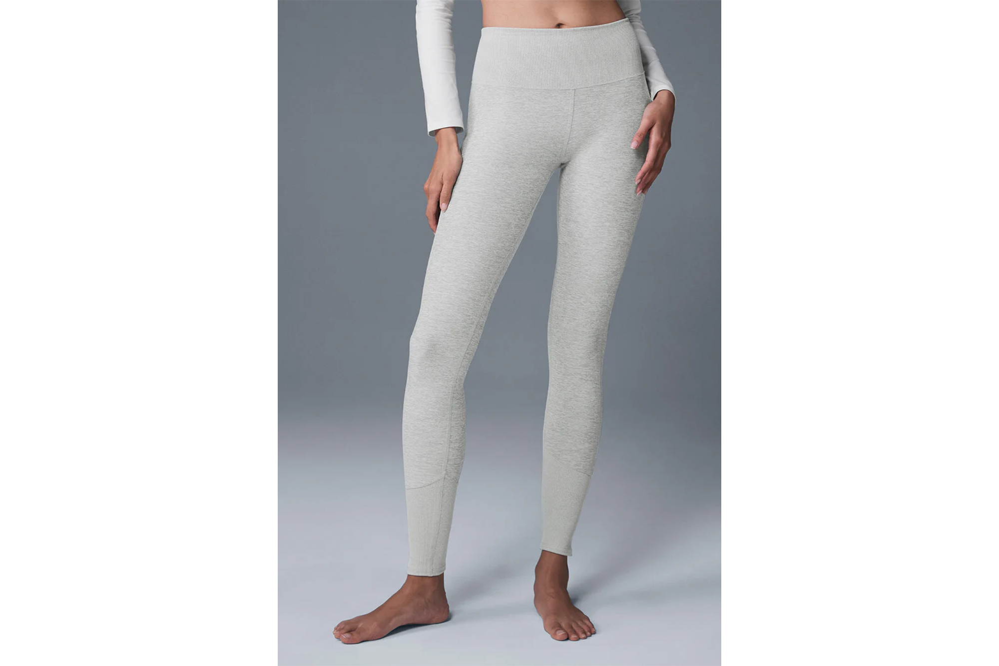A person wearing light gray leggings with a ribbed waistband and cuffs.