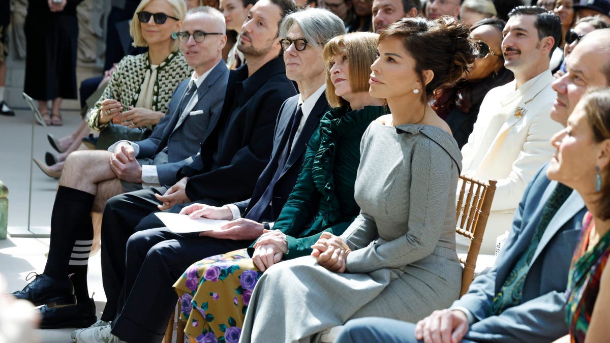 Tory Burch, Thom Browne, Anthony Vaccarello, Andrew Bolton, Anna Wintour and Lauren Sánchez Bezos standing at a press conference