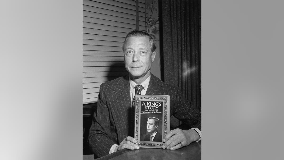 The Duke of Windsor holding his memoirs titled A King's Story