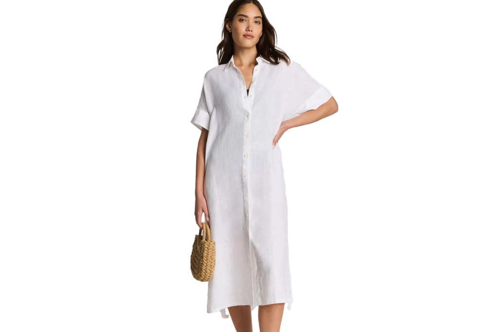 A woman wearing a white short-sleeved collared midi dress with a straw handbag.