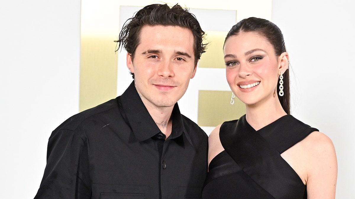 Brooklyn beckham and Nicola Peltz stand side by side