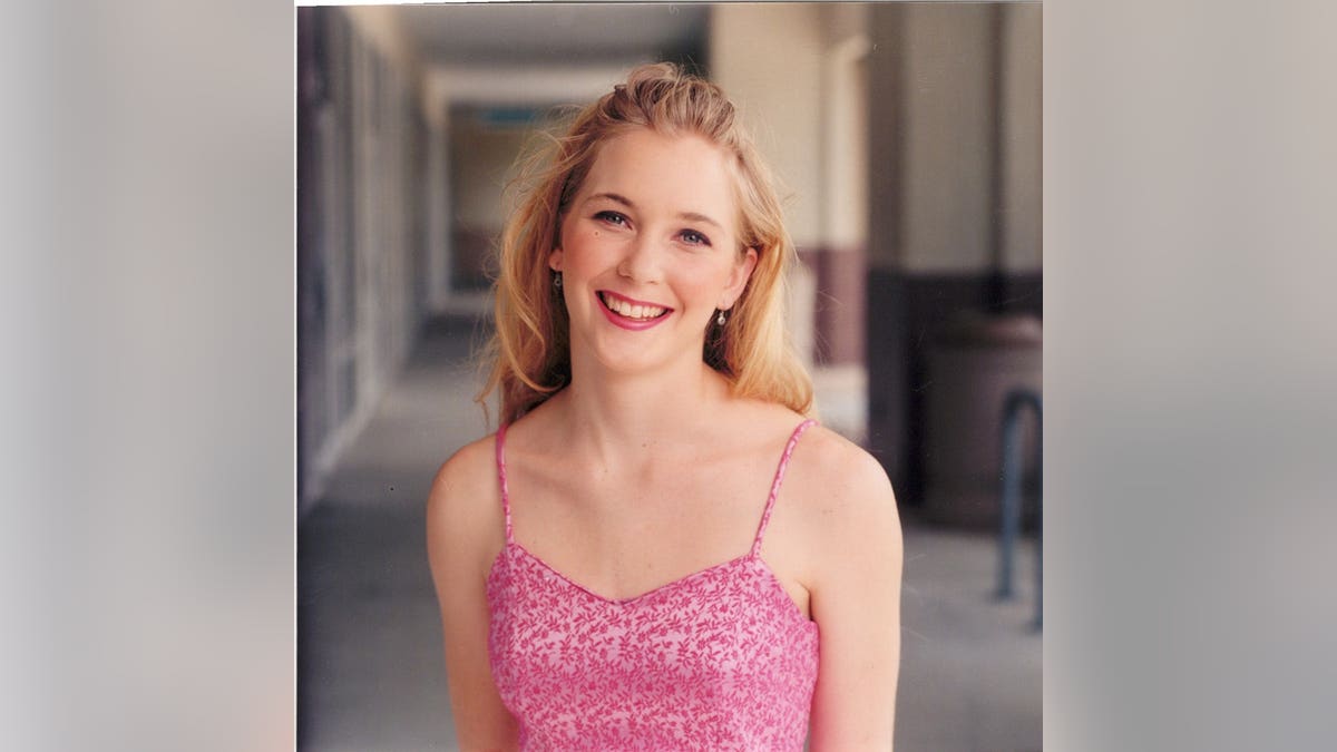 A young Virginia Roberts Giuffre smiling in a pink top.