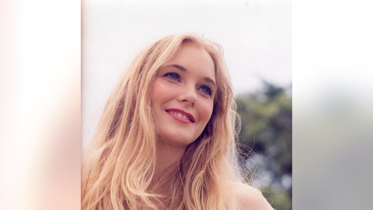 A close-up of Virginia Roberts Giuffre outdoors smiling away from the camera.