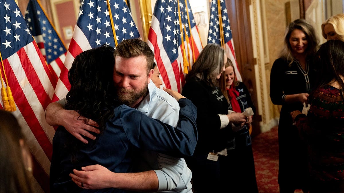 Sky Roberts embracing an attendee at a news conference in Washington, D.C.