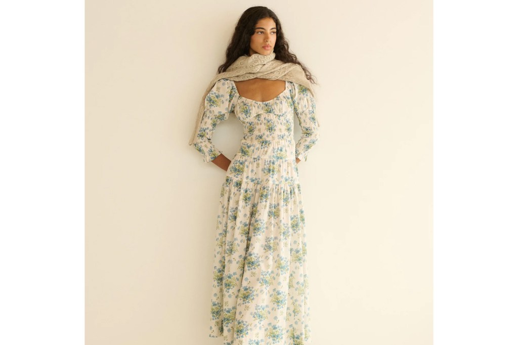 Woman in a floral maxi dress with a knitted scarf.