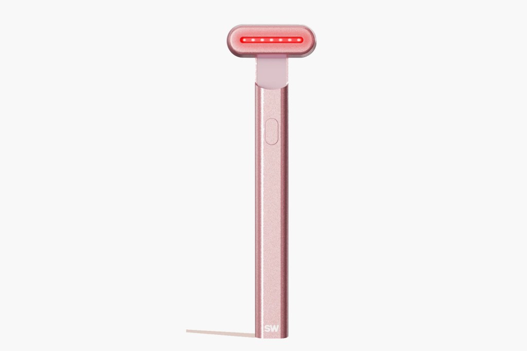 Rose gold facial wand with five red lights on its head.